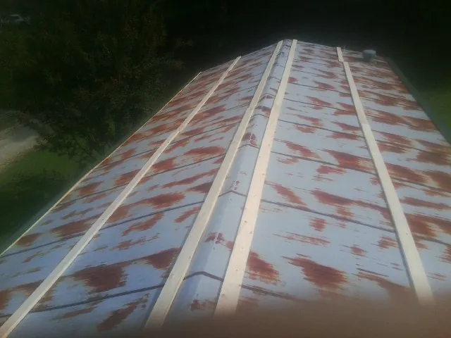Rusted metal roof panels with new wood purlins before replacement — Storm Damage Roof Repair in Minersville by Roofing Brothers