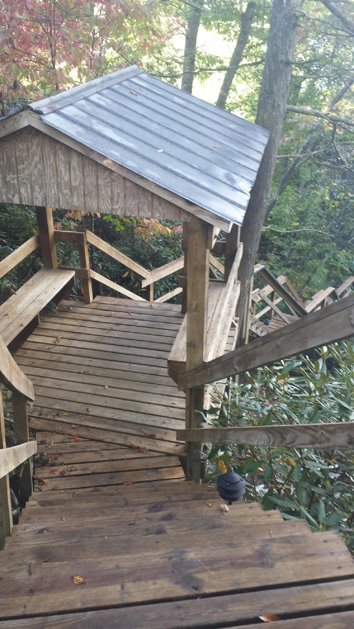 Metal roofed shelter over wooden steps on a wooded walkway — Skylight Repair & Installation work by our crew in Minersville